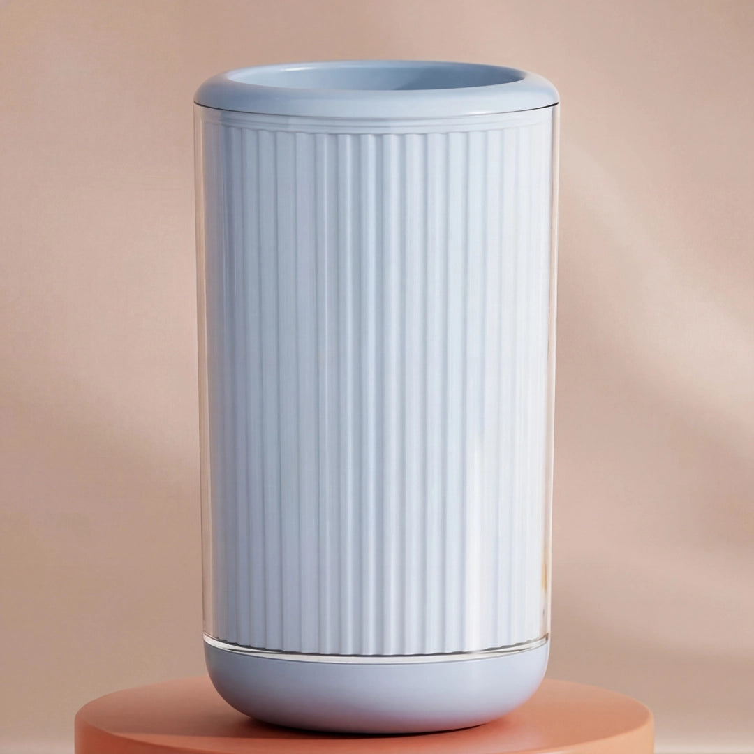 Light blue cylindrical pet paw cleaner with ribbed texture on a peach-colored background