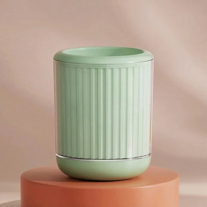 Green textured cylindrical pet paw cleaner on a peach-colored platform with a beige background