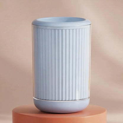 Blue cylindrical pet paw cleaner with ribbed texture on a peach-colored background