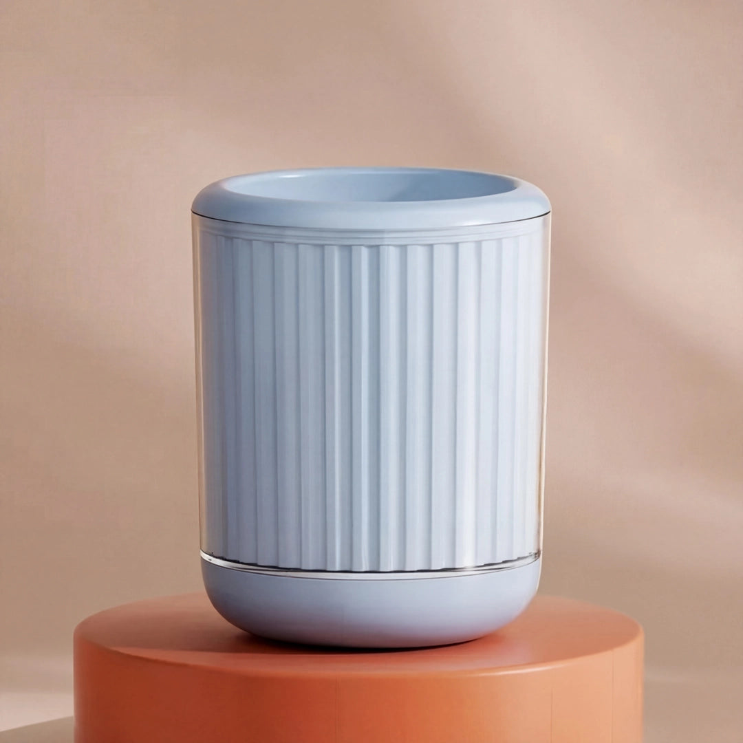 Light blue cylindrical pet paw cleaner with ribbed texture on a peach-colored background